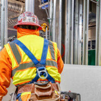 Professional drywall installer preparing to install a sheet of type X fire-rated gypsum board